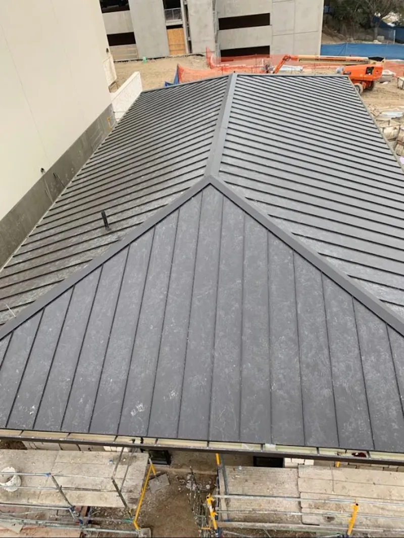 Commercial metal roof construction with crane equipment in Fort Polk South